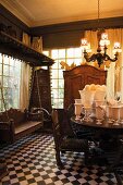 Herrschaftlicher Raum mit antiken Möbeln, einer hölzernen Hollywoodschaukel und einer weissen Vasensammlung auf dem Esstisch