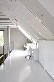 Home-Office auf Loft-Galerie unter weiss lackierten Sparren mit Belichtung durch eine Dachgaube