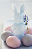 An Easter bunny with a grape hyacinth and pastel-coloured Easter eggs