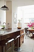 Open-plan kitchen with dining area and designer bar stools at counter