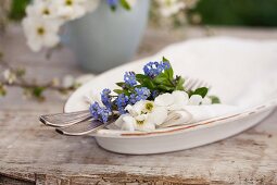 A place setting decorated with forget-me-not and garden jasmine