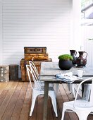 Retro-look metal chairs and simple wooden table on terrace with wooden floor