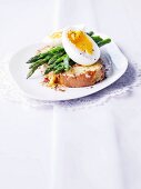 Cheese on toast topped with lemon zest, asparagus and egg