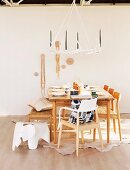 Stools and chairs at set dining table below chandelier made from antlers