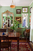 Esstisch und Stühle aus dunklem Holz in Jugendstil Wohnzimmer mit grün getönter Wand