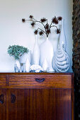 Dried flowers in a collection of vases on a sideboard