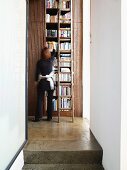 View of tall bookcase with vintage ladder from stairwell