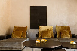 Sofa and couch with grey velvet upholstery and gold cushions in minimalist room