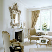 Elegant, traditional living room with Rococo-style armchairs and coffee table in front of open fireplace