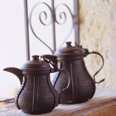 Dark, metal Moroccan teapots on windowsill