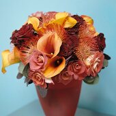 Shades of dusky pink and yellow against light blue wall - sumptuous bouquet in colour-coordinated vase