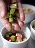 A hand holding marinated rhubarb pieces