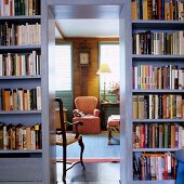 Bücherwand mit offenem Durchgang und Blick auf Sessel in ländlichem Stil