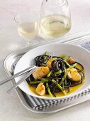 Squid ink pasta with salmon and Thai asparagus in a saffron sauce