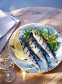 Grilled sardines with lemon wedges