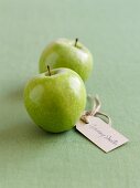 Two Granny Smith apples with a label