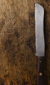 A bread knife on a wooden surface