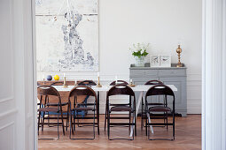 View through open door of white dining table and folding chairs in dining room with traditional ambiance