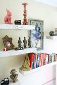 Alte Wandregale aus Holz mit Büchern & verschiedenen Dekogegenständen in Wohnzimmer