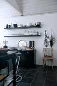 Flagons, carafes, antique soda siphon and goblet - flea market treasures on rusty metal cabinet against brick wall