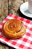 A puff pastry spiral on a checked cloth