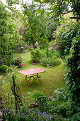 Garden table on lawn of wild garden