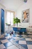 Bathroom with blue and white floor tiles, free-standing bathtub and separate shower area