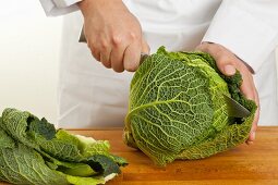 A savoy cabbage being cut in half