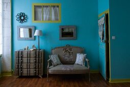 Bedroom in original combination of colours and fabrics - grey striped chest of drawers and matching antique sofa against walls painted blue and green