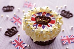 A cupcake topped with cream and a Union Jack surrounded by chocolate crowns