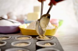 Cupcake mixture being spooned into paper cases