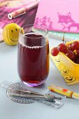 A glass of red grape juice with school things