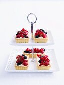 White chocolate tarts with berries on a cake stand