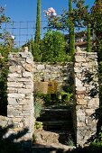 Blick zwischen Natursteinpfosten in mediterranen Garten