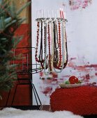 Lampenschirmgestell mit Perlenketten und Kerzen dekoriert als festlicher Kerzenleuchter