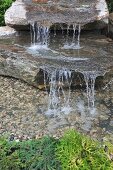 Waterfall falling over large stone slabs