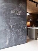 Floor-to-ceiling blackboard partition covered with children's drawings