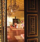 Open black double door with gilt inlays and view into grand salon with Oriental atmosphere