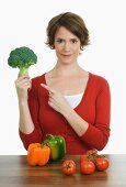 Woman with broccoli, pepper and tomatoes