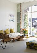 Various types of seating with flea-market charm in front of open balcony door of loft-style interior