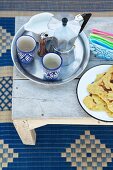 Tablett mit Espresso-Kanne und Bechern neben Teller mit marokkanischem Fladenbrot