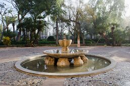 Platz mit altem Zierbrunnen in mediterranem Garten