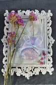 Easter egg with ribbon bow on white-painted vintage picture frame