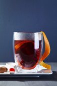 A glass of mulled wine with orange peel