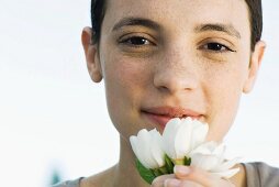 Frauenportrait und weiße Blumen in Hand haltend