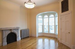 Empty room in apartment with hardwood floor and bay window