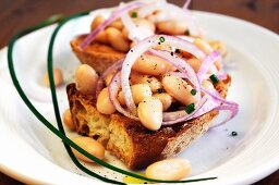 Bruschetta ai fagioli (toasted bread topped with beans and onions)