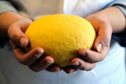 A chef holding a ball of pasta dough