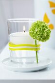 Floating candle in glass with flower held on by rubber band
