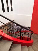 Helical stairwell with red inner stringer and black-painted banister